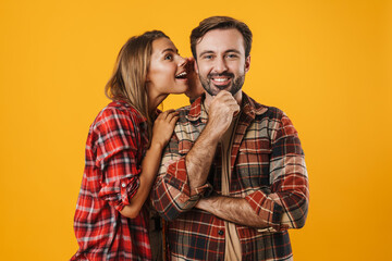 Pleased blonde woman whispering secret at smiling man