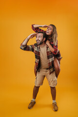 Happy unshaven man piggyback riding his funny girlfriend