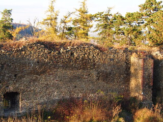 autumn afternoon in the woods near the ruins of an old stone castle, sunny cold day, wild nature, adventure trip, travel