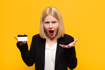 blonde woman looking angry, annoyed and frustrated screaming wtf or what’s wrong with you
