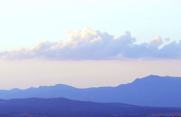 Sierra de Guadarrama vista desde el norte de la ciudad de Madrid, España. Fondo natural donde se aprecia la silueta de las montañas y las nubes con los últimos rayos de sol del día.