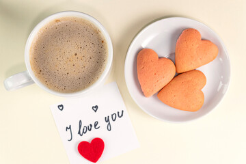 Cup of coffee, and a note with the words I love you on pastel yellow color. Valentine's Day breakfast. Valentine's day concept.