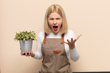 blonde woman looking angry, annoyed and frustrated screaming wtf or what’s wrong with you