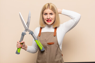 blonde woman feeling stressed, worried, anxious or scared, with hands on head, panicking at mistake