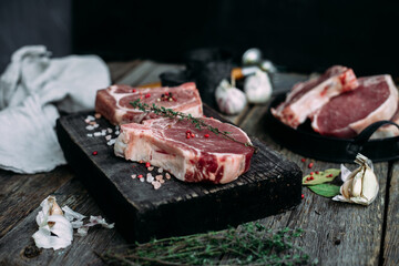 Raw pork steak on the bone on a wooden table. Cooking meat