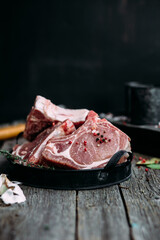 Raw pork steak on the bone on a wooden table. Cooking meat