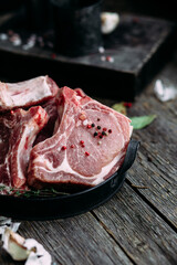 Raw pork steak on the bone on a wooden table. Cooking meat