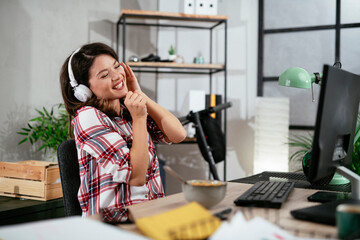 Portrait of businesswoman in office. Beautiful woman listening music at work..