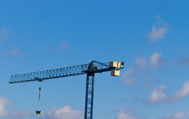 A green crane in contrast with the blue sky