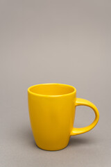 yellow mug with hot beverage on grey with copy space