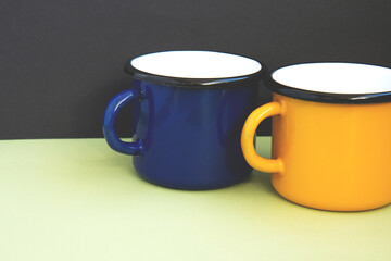 Two iron mugs on the table. Side view with copy space