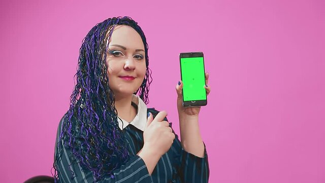 Stylish brunette jewish woman with blue afro braids leafing through the smartphone screen green screen