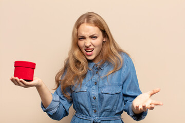 blonde woman looking angry, annoyed and frustrated screaming wtf or what’s wrong with you