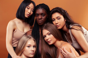 Fototapeta premium SaveDownload Previewyoung pretty asian, caucasian, afro woman posing cheerful together on brown background, lifestyle diverse nationality people concept