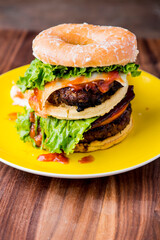 amburger. Bacon Cheeseburger. Classic traditional American bar, restaurant entree. Beef hamburger with Swiss and cheddar cheeses served with lettuce, tomato, onion and hand cut french fries. 