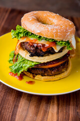 amburger. Bacon Cheeseburger. Classic traditional American bar, restaurant entree. Beef hamburger with Swiss and cheddar cheeses served with lettuce, tomato, onion and hand cut french fries. 