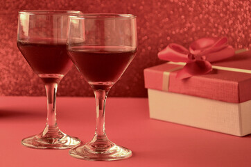 two wine glasses with gift and festive background