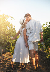 Happy Valentines Day. Couple with glasses drinks wine in vineyard