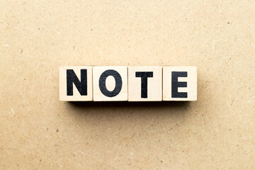 Alphabet letter block in word note on wood background