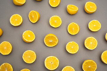 top view of halves of fresh and ripe lemons on grey