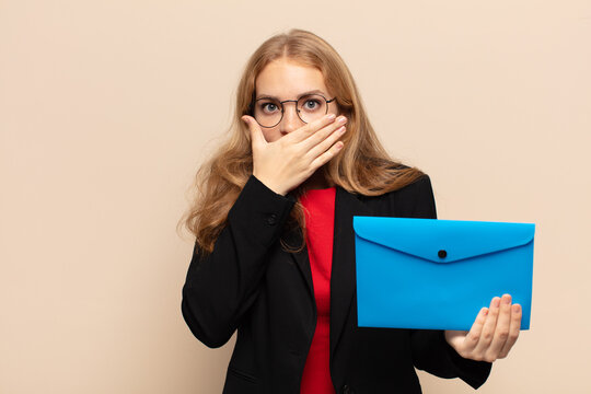 blonde woman covering mouth with hands with a shocked, surprised expression, keeping a secret or saying oops