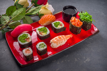 Valentine day festive dinner idea. Menu, invitation background for Valentine day sushi roll set, with heart shaped decor and rose flowers bouquet. Top view with copy space for text