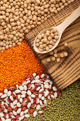 Assorted legumes in wooden spoon top view