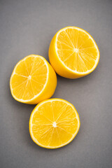 Fototapeta na wymiar top view of three halves of juicy lemons on grey background