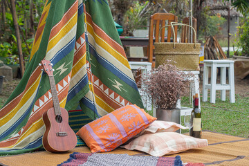 Outdoors area decorated in a Bohemian style with a tent from colorful fabrics, and decorated with...