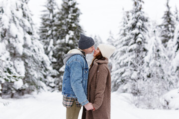 beautiful young couple in love kissing in winter forest.
