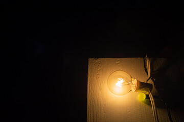 Obraz na płótnie Canvas Light bulbs placed on a wooden chair a part of outdoor party decor
