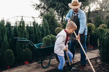 grandfather and grandson enjoying time together outdoors in family plant nursery