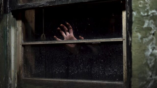 Woman trapped in abandoned house, hand emerged from shade hit window glass