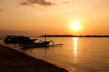 Quet sunset on Gili island Indonesia. Traditional Balinese boats in silhouette in sunset background
