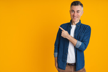 Happy handsome man smiling and pointing finger aside