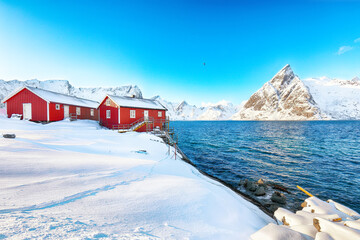 Traditional Norwegian red wooden houses on the shore of  Reinefjorden on Toppoya island