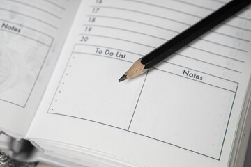 Pencil on opened diary notebook. Empty To do list and Notes. Close-up.