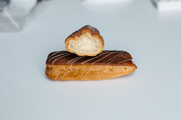 Traditional french dessert. Isolated eclair with custard and chocolate icing on white background....