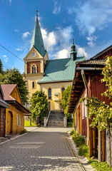 Fototapeta na wymiar St. John street leading to St. John Baptist Church in historic royal open-air museum town of Lanckorona in mountain region of Lesser Poland