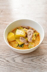 spicy boiled pumpkin with slice pork in curry on bowl