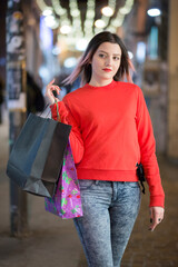 Bella ragazza con i capelli castani dipinti di viole , vestita con dei jeans e un maglione rosso,...