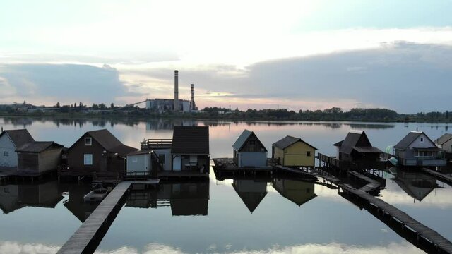 Aerial pan shot of Sunset Over Lake Bokod With Wooden Pier And Floating Houses in Hungary.