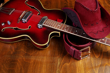 Fototapeta premium Jazz guitar, cowboy hat and belt on a wooden background.