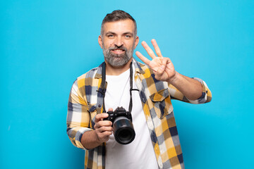 adult man smiling and looking friendly, showing number three or third with hand forward, counting down