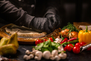 Tasty pepperoni pizza and cooking ingredients tomatoes basil on black concrete background. Top view of hot pepperoni pizza. With copy space for text. Flat lay. Banner