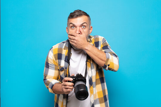 adult man covering mouth with hands with a shocked, surprised expression, keeping a secret or saying oops