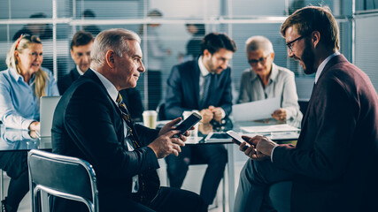 business colleagues using their smartphones during a work meeting