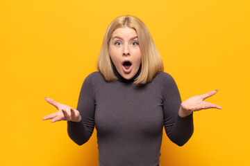 blonde woman open-mouthed and amazed, shocked and astonished with an unbelievable surprise
