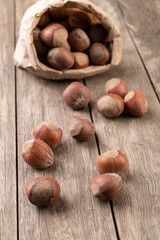 Hazelnuts in a paper bag over wooden table