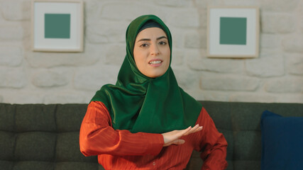Young muslim woman shows she made a stupid mistake by banging her forehead.Portrait of the woman...
